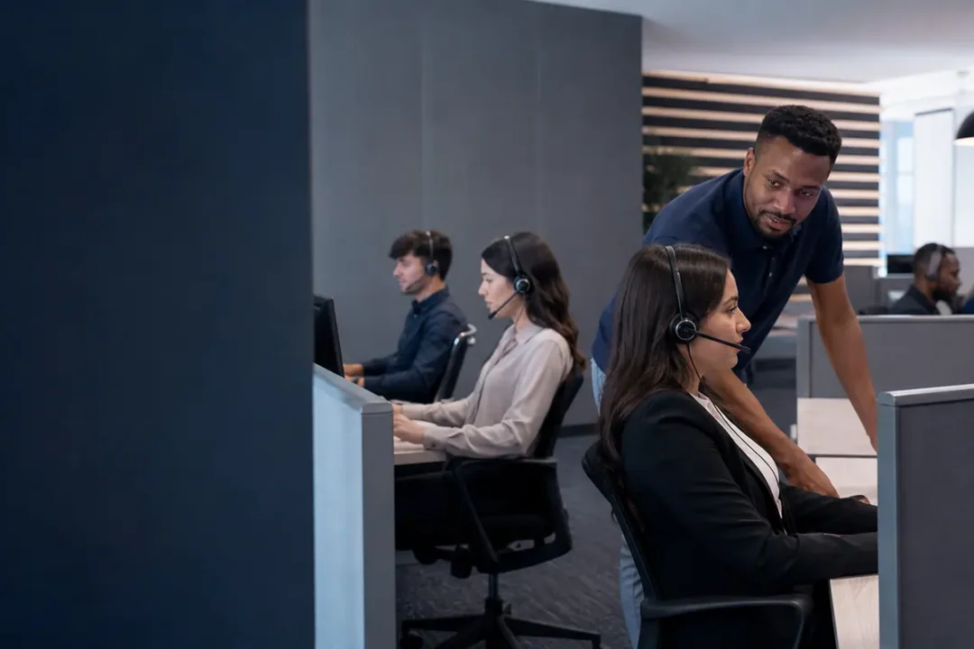 Supervisor supporting headset agents handling calls at a contact centre workstation