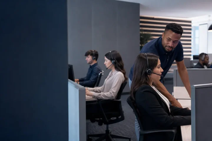 Supervisor supporting headset agents handling calls at a contact centre workstation