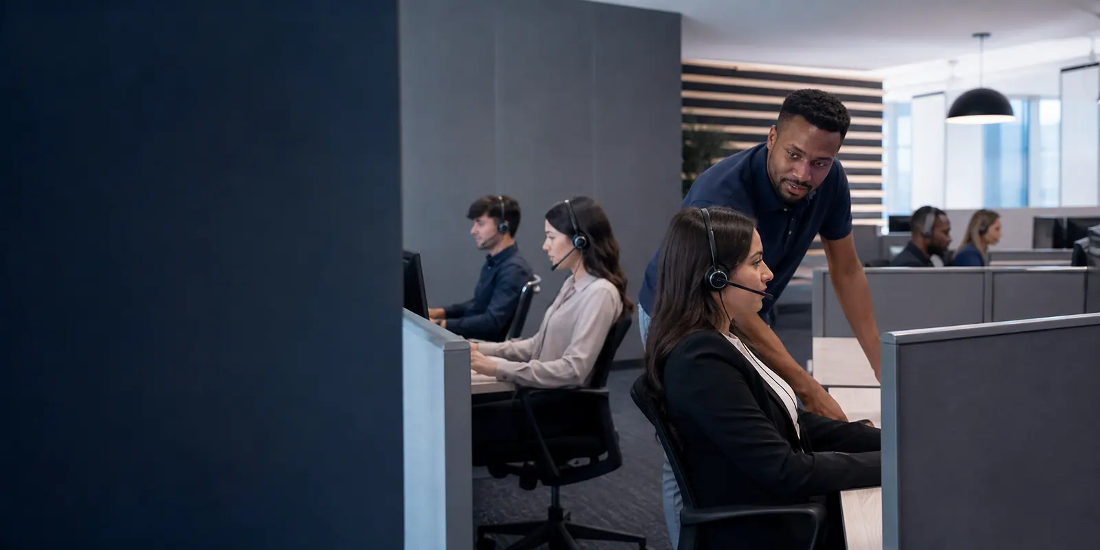 Supervisor supporting headset agents handling calls at a contact centre workstation